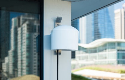 PurpleAir PA-II sensor mounted on exterior wall